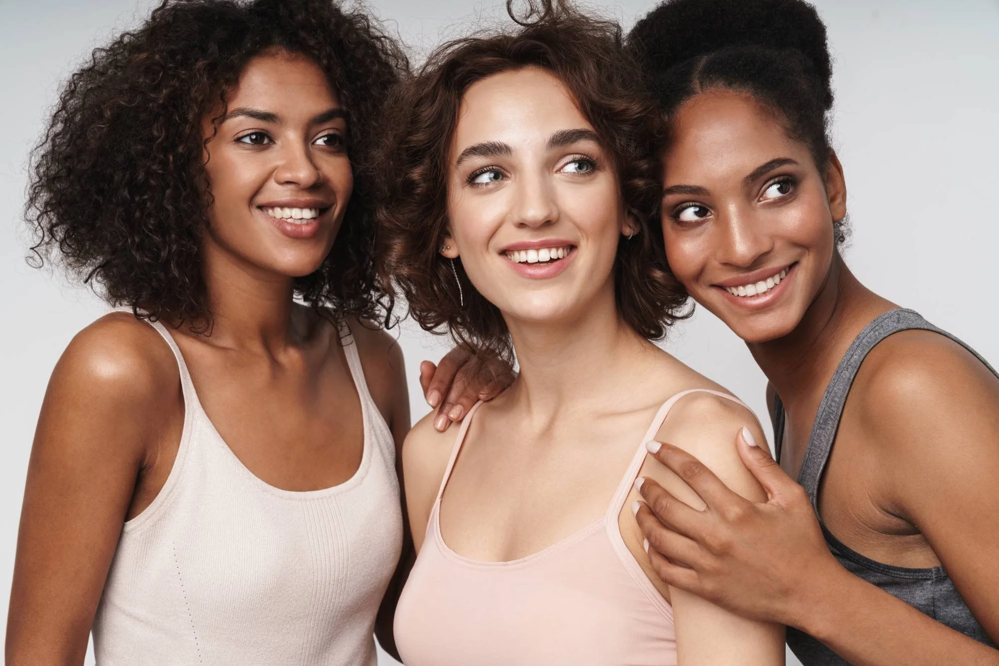Three women smiling together at Misch Facial Plastics